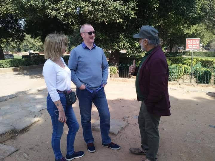 बिटटू बेकार speaking with international visitors at a heritage park