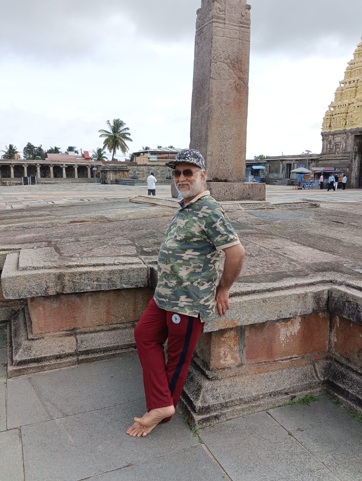 बिटटू बेकार resting against a stone plinth in a temple courtyard