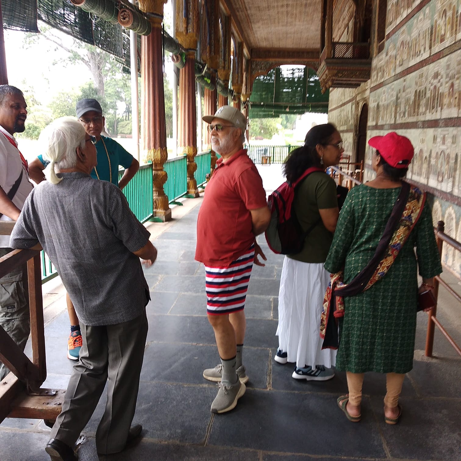 बिटटू बेकार guiding a group along the painted corridor of the Mysore Palace