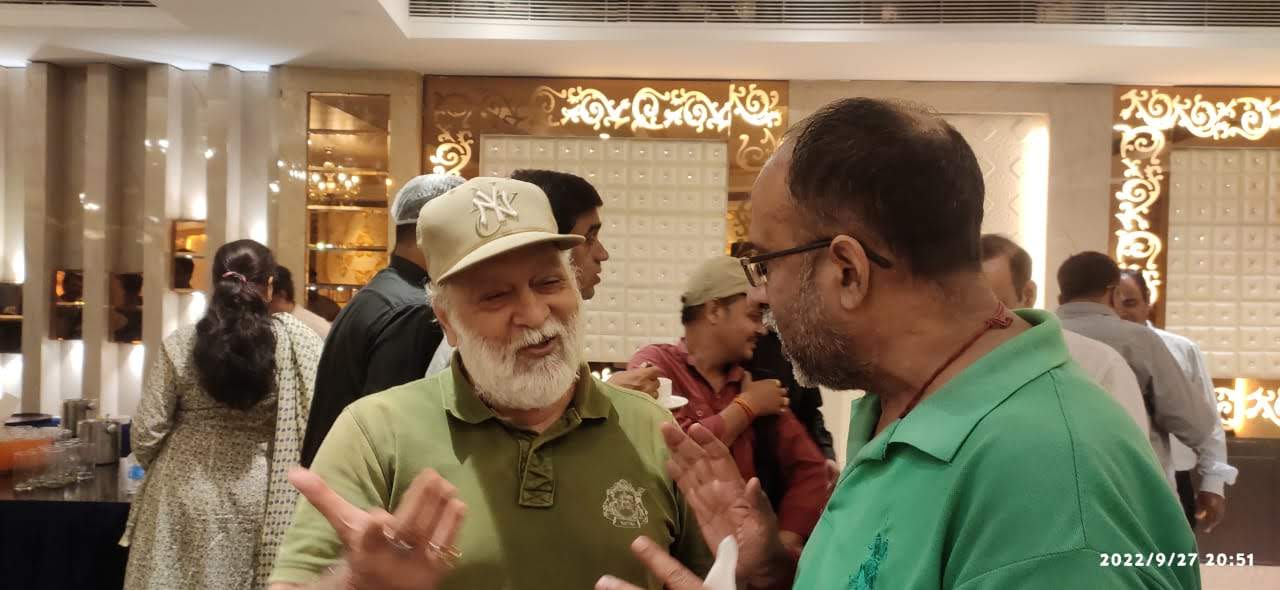 बिटटू बेकार in conversation with a colleague at an evening banquet